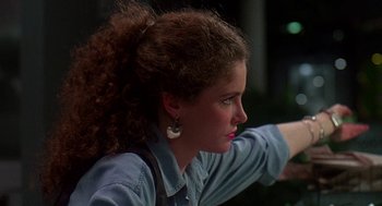 Movie still from “Talk Radio” (1988), directed by Oliver Stone – A woman with curly brown hair wearing a blue shirt; Close Up shot, Low angle