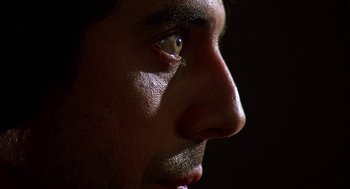 Movie still from “Talk Radio” (1988), directed by Oliver Stone – A man's face with the sun shining on his face; Extreme Close Up shot, Low angle