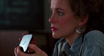 Movie still from “Talk Radio” (1988), directed by Oliver Stone – A person using a cell phone; Close Up shot, Over the shoulder angle