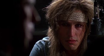 Movie still from “Talk Radio” (1988), directed by Oliver Stone – A person wearing a headband; Close Up shot, Over the shoulder angle
