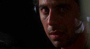 Movie still from “Talk Radio” (1988), directed by Oliver Stone – A person wearing headphones; Close Up shot, Low angle