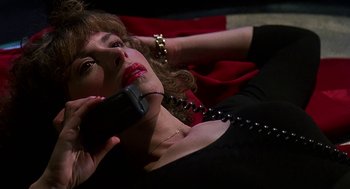 Movie still from “Talk Radio” (1988), directed by Oliver Stone – A woman is talking on a phone while lying down; Close Up shot, High angle