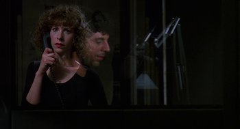 Movie still from “Talk Radio” (1988), directed by Oliver Stone – A man and a woman looking out of a window; Close Up shot, Over the shoulder angle