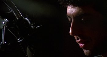 Movie still from “Talk Radio” (1988), directed by Oliver Stone – A person's face in the dark; Close Up shot, Low angle