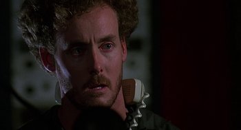 Movie still from “Talk Radio” (1988), directed by Oliver Stone – A person holding a phone; Close Up shot, Low angle