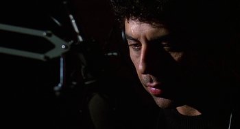 Movie still from “Talk Radio” (1988), directed by Oliver Stone – A man's face in the dark; Close Up shot, Low angle