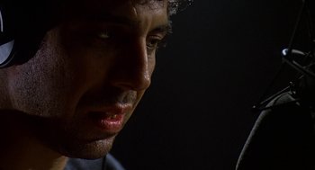 Movie still from “Talk Radio” (1988), directed by Oliver Stone – A man's face in the dark; Close Up shot, Low angle