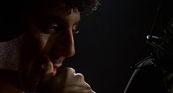 Movie still from “Talk Radio” (1988), directed by Oliver Stone – A person looking at a cell phone; Close Up shot, Low angle