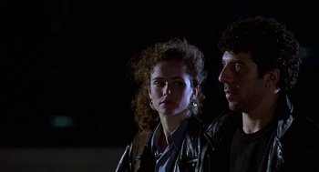 Movie still from “Talk Radio” (1988), directed by Oliver Stone – A man and a woman standing next to each other in the dark; Close Up shot, Low angle