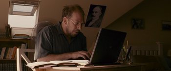 Movie still from “Tamara Drewe” (2010), directed by Stephen Frears – A man sitting in front of a laptop computer; Medium shot, Low angle