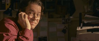 Movie still from “Tamara Drewe” (2010), directed by Stephen Frears – A man with glasses is looking at the camera; Close Up shot, Low angle