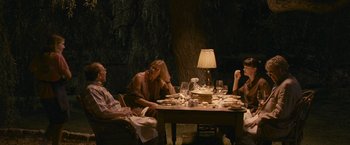 Movie still from “Tamara Drewe” (2010), directed by Stephen Frears – A group of people sitting around a table with food on top of it; Wide shot, High angle