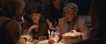 Movie still from “Tamara Drewe” (2010), directed by Stephen Frears – Two people sitting at a dinner table with wine glasses; Medium shot, Over the shoulder angle