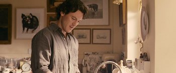 Movie still from “Tamara Drewe” (2010), directed by Stephen Frears – A man standing in front of a mirror in a living room; Medium shot, Low angle