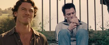 Movie still from “Tamara Drewe” (2010), directed by Stephen Frears – Two men sitting next to each other on the ground; Medium shot, Over the shoulder angle