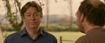 Movie still from “Tamara Drewe” (2010), directed by Stephen Frears – A person wearing a blue shirt; Close Up shot, Over the shoulder angle