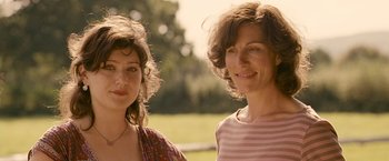 Movie still from “Tamara Drewe” (2010), directed by Stephen Frears – Two women standing next to each other on a field; Close Up shot, Low angle