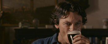 Movie still from “Tamara Drewe” (2010), directed by Stephen Frears – A person drinking a glass of wine; Close Up shot, Over the shoulder angle