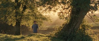 Movie still from “Tamara Drewe” (2010), directed by Stephen Frears – A man standing under a tree in the middle of a field; Wide shot, Low angle
