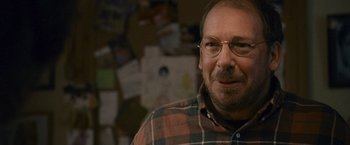 Movie still from “Tamara Drewe” (2010), directed by Stephen Frears – A person wearing glasses and a plaid shirt; Close Up shot, Over the shoulder angle