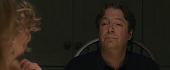 Movie still from “Tamara Drewe” (2010), directed by Stephen Frears – A person sitting in a chair; Close Up shot, Low angle