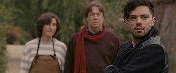 Movie still from “Tamara Drewe” (2010), directed by Stephen Frears – A group of people standing next to each other in a park; Medium shot, Over the shoulder angle