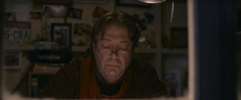 Movie still from “Tamara Drewe” (2010), directed by Stephen Frears – An older man with glasses is sitting in front of a computer; Close Up shot, Over the shoulder angle