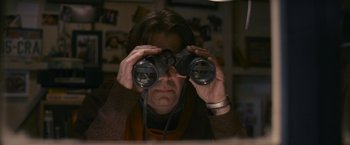 Movie still from “Tamara Drewe” (2010), directed by Stephen Frears – A man looking through a pair of binoculars; Medium shot, High angle