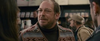 Movie still from “Tamara Drewe” (2010), directed by Stephen Frears – An older man wearing glasses and a sweater; Close Up shot, Over the shoulder angle