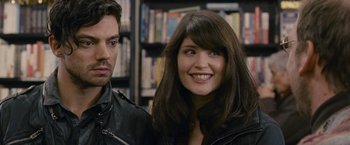 Movie still from “Tamara Drewe” (2010), directed by Stephen Frears – A man and a woman standing next to each other in a library; Close Up shot, Over the shoulder angle