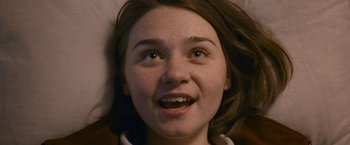 Movie still from “Tamara Drewe” (2010), directed by Stephen Frears – A young woman's face with a smile; Close Up shot, Overhead angle