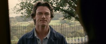 Movie still from “Tamara Drewe” (2010), directed by Stephen Frears – A person wearing a jacket near a tree; Close Up shot, Over the shoulder angle