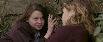 Movie still from “Tamara Drewe” (2010), directed by Stephen Frears – A woman looking at another woman's face in a forest; Close Up shot, Over the shoulder angle