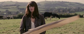Movie still from “Tamara Drewe” (2010), directed by Stephen Frears – A woman standing next to a fence with cows in the background; Medium shot, Over the shoulder angle
