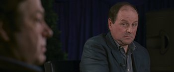 Movie still from “Tamara Drewe” (2010), directed by Stephen Frears – A person wearing a suit and tie; Close Up shot, Over the shoulder angle