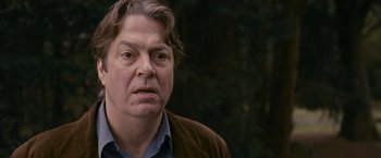 Movie still from “Tamara Drewe” (2010), directed by Stephen Frears – A person wearing a brown jacket; Close Up shot, Over the shoulder angle