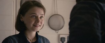 Movie still from “Tamara Drewe” (2010), directed by Stephen Frears – A young woman smiles at the camera in front of a mirror; Close Up shot, Over the shoulder angle