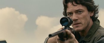 Movie still from “Tamara Drewe” (2010), directed by Stephen Frears – A man is holding a rifle and aiming it; Close Up shot, Low angle