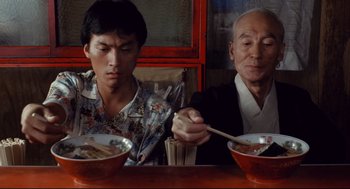Two people sitting at a table with two bowls of food