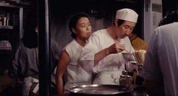 A man and a woman in a kitchen preparing food