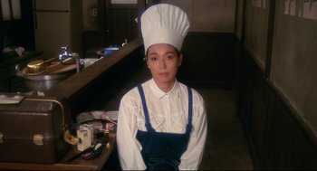 A person wearing a chef's hat in a room