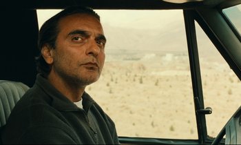 Movie still from “Taste of Cherry” (1997), directed by Abbas Kiarostami – A man sitting in a car looking out the window; Close Up shot, Over the shoulder angle