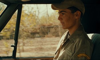 Movie still from “Taste of Cherry” (1997), directed by Abbas Kiarostami – A man in a hat looking out the window of a vehicle; Close Up shot, Over the shoulder angle