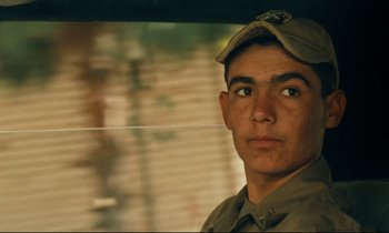 Movie still from “Taste of Cherry” (1997), directed by Abbas Kiarostami – A man wearing a hat and looking at the camera; Close Up shot, Low angle