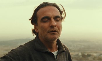 Movie still from “Taste of Cherry” (1997), directed by Abbas Kiarostami – A person with his eyes closed; Close Up shot, Low angle