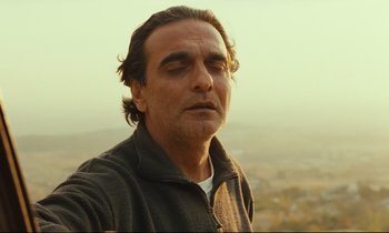 Movie still from “Taste of Cherry” (1997), directed by Abbas Kiarostami – A person wearing a jacket; Close Up shot, Low angle