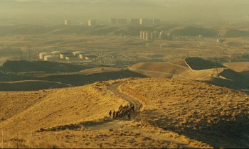 Movie still from “Taste of Cherry” (1997), directed by Abbas Kiarostami – A group of people riding horses down a dirt road; Extreme Wide shot, High angle