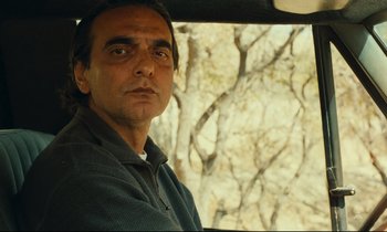 Movie still from “Taste of Cherry” (1997), directed by Abbas Kiarostami – A person sitting in a car; Close Up shot, High angle