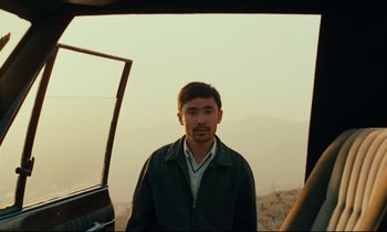 Movie still from “Taste of Cherry” (1997), directed by Abbas Kiarostami – A man standing in front of a vehicle; Close Up shot, Low angle