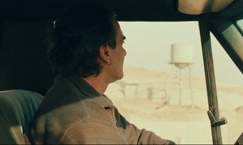 Movie still from “Taste of Cherry” (1997), directed by Abbas Kiarostami – A man sitting in the driver's seat of a car; Close Up shot, Over the shoulder angle
